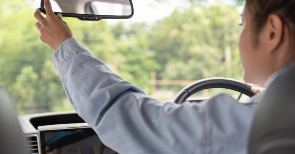 Person driving and checking rearview mirror
