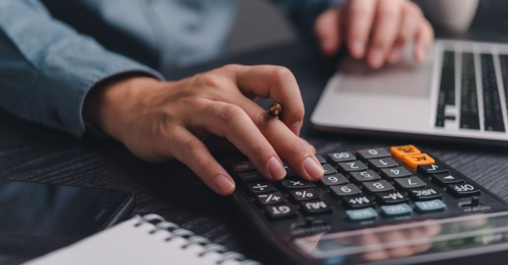 A person typing on a calculator.