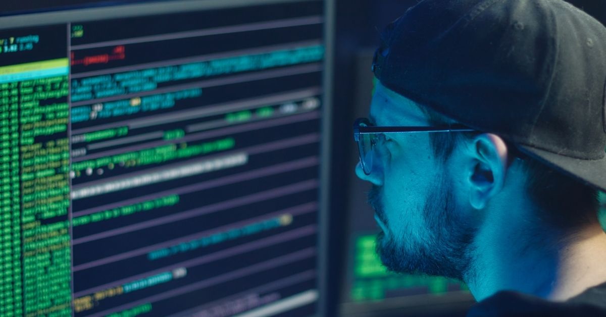 A man looking at a computer screen of code sequences.