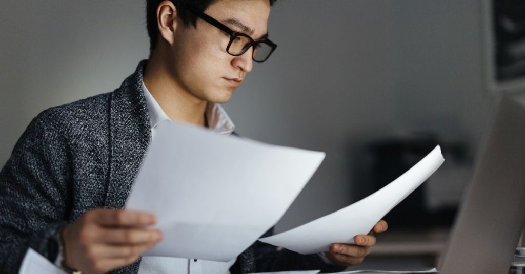 A man reading two separate documents side by side.