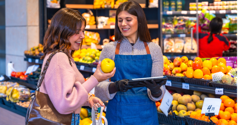 Woman speaking to a store associate about a fruit in a supermarket