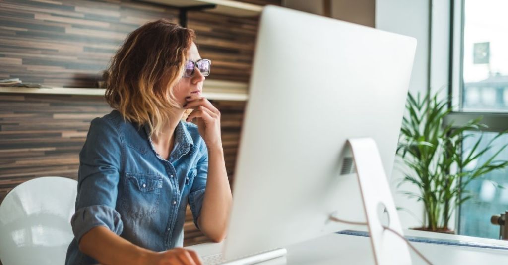 A woman concentrating looking at a computer screen,