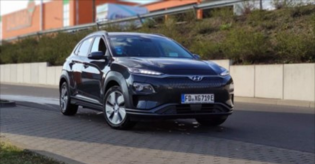 A black sedan driving down a road