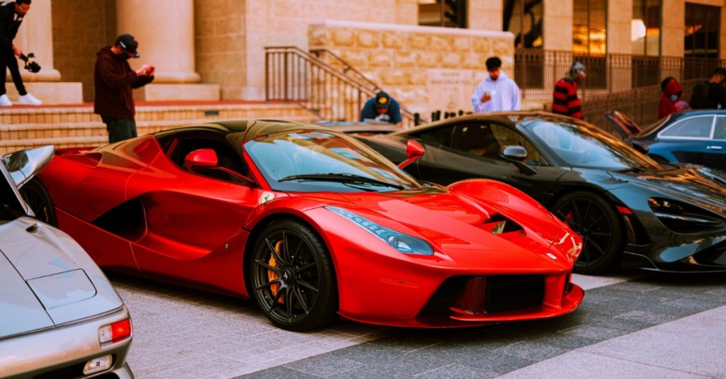 A row of luxury cars backed into parking spots.