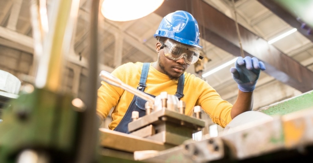 A manufacturing worker looking at a machine.