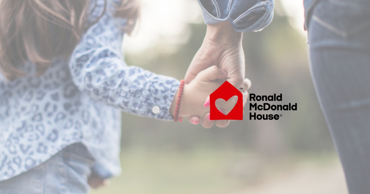 Ronald McDonald House logo with a background image of a child holding hands with their parent.