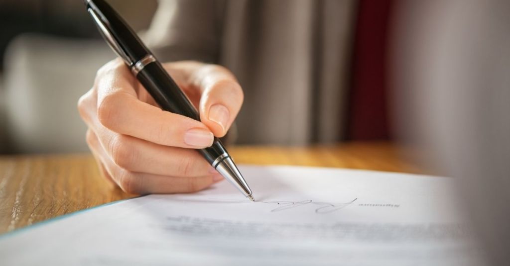Person signing a document.