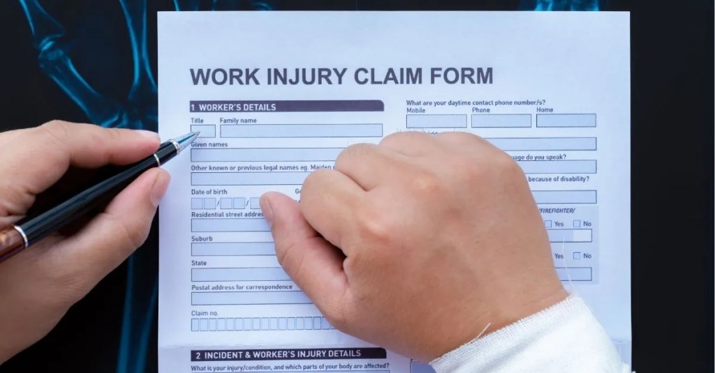 A person filling out a work injury claim form.